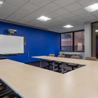 Conference Room 103A with U-shaped long table, chairs, and large windows, after renovation